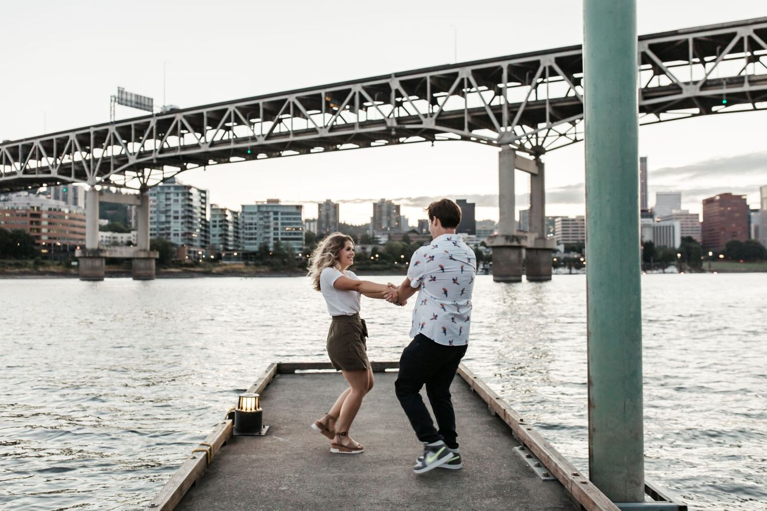 Summer engagement photo on Portland waterfront with girl and boy dancing