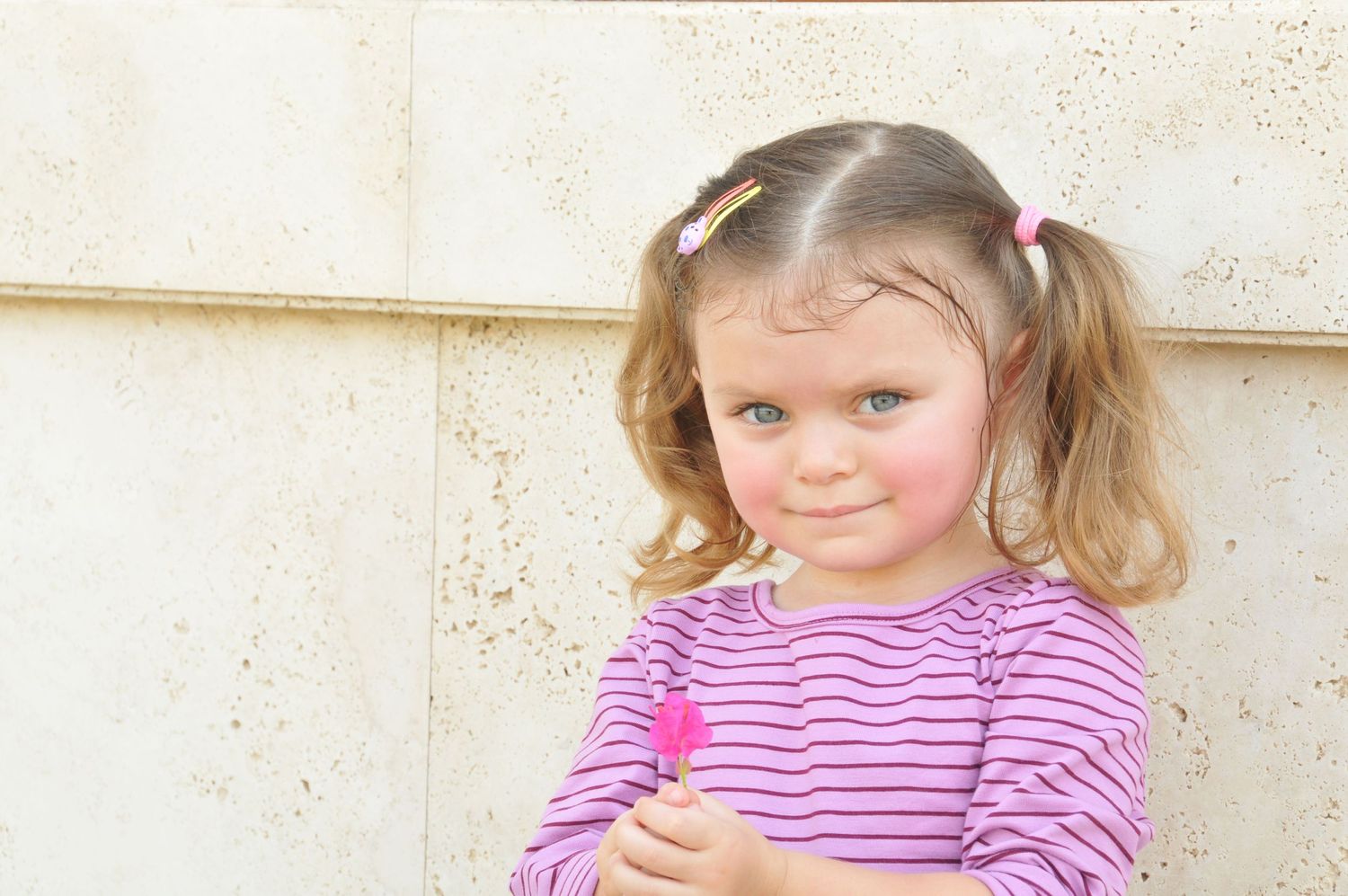 Photo of a young girl holding a flower