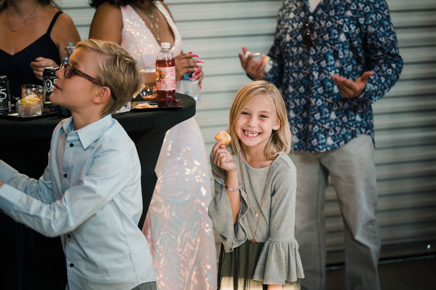 Young guests enjoying refreshments at an outdoor wedding reception.