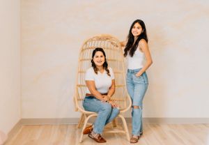 Person in casual denim and white top sitting casually in studio setting.