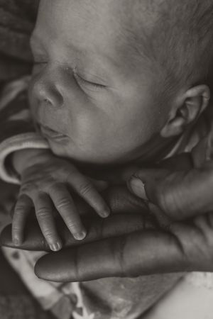 Close-up black and white portrait of a sleeping newborn baby's delicate features.
