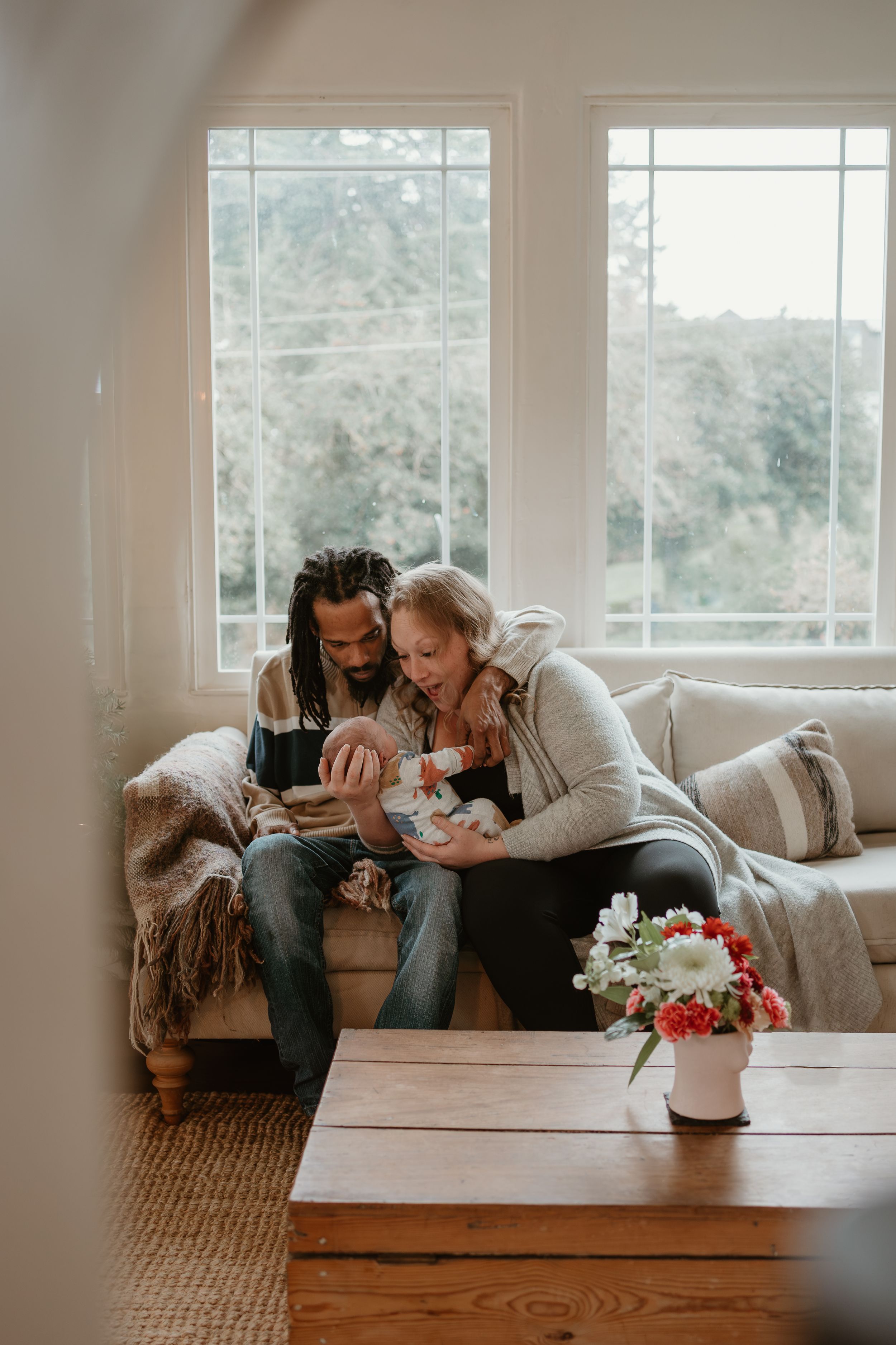 A cozy living room scene with a couple sharing a tender moment on the sofa.