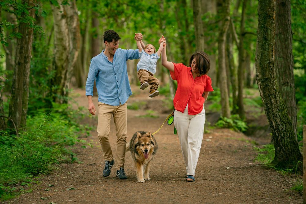 Toddler with his parents playing together on family photoshoot in Camberley