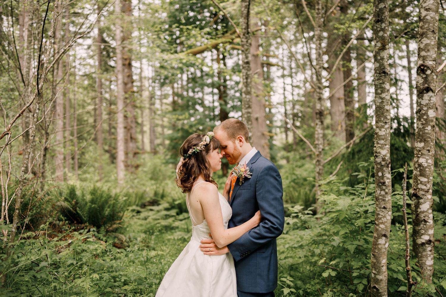 young married couple embrace in a bright forest