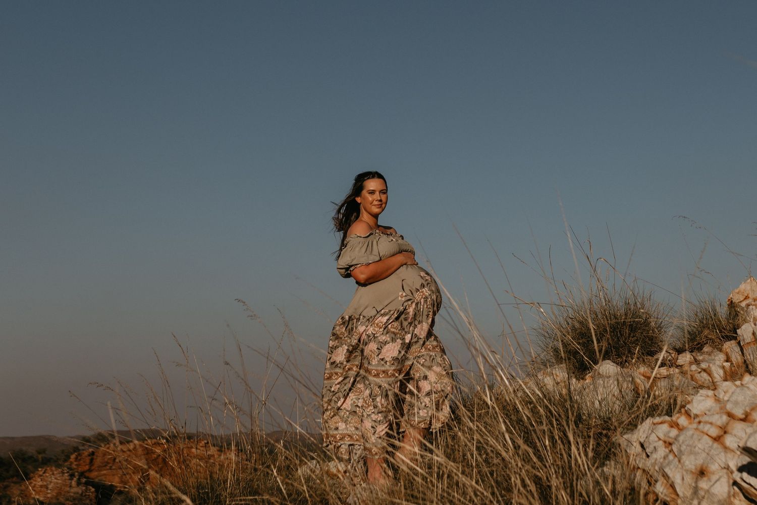 Maternity photoshoot of mother in outback hills
