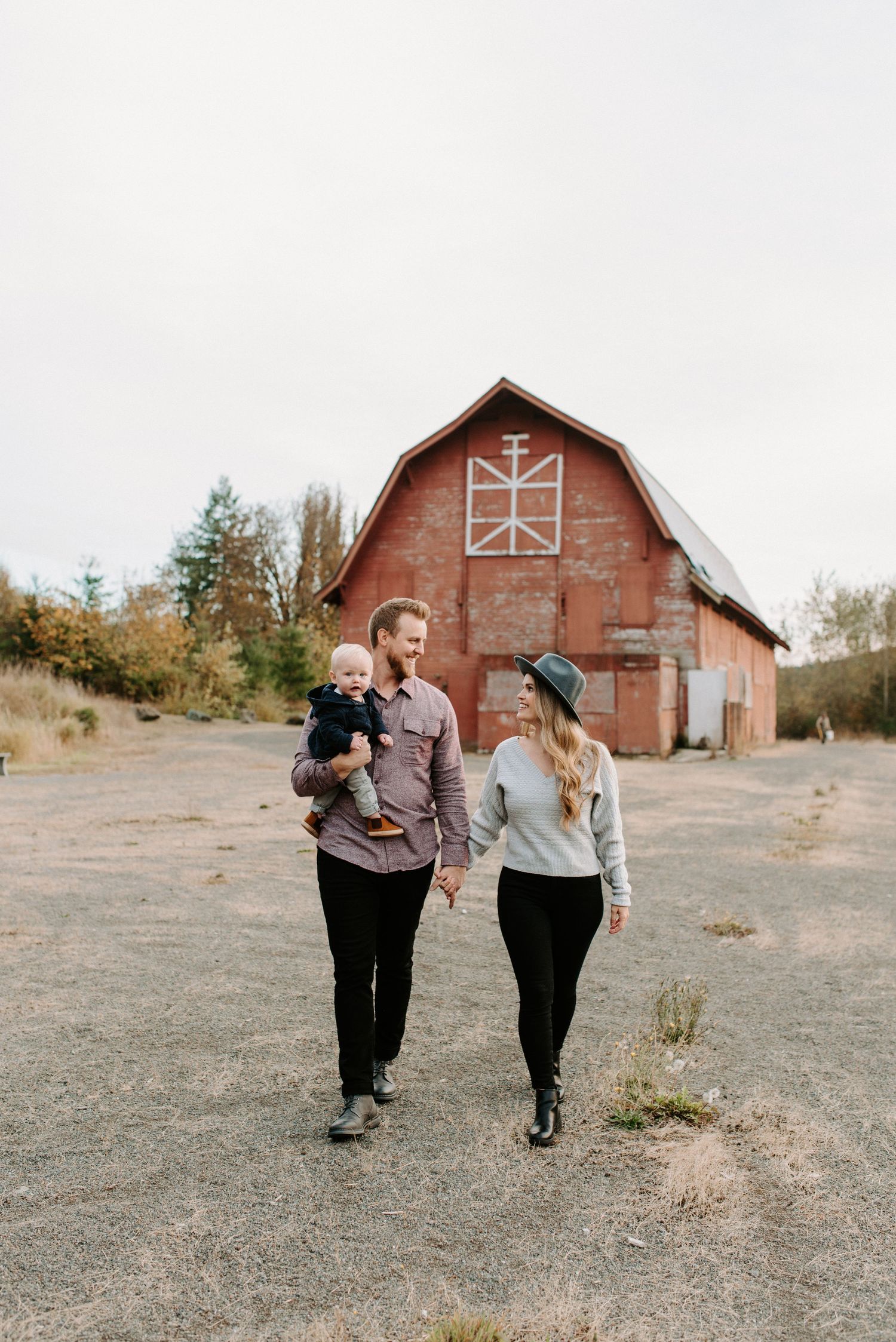 Sequence of people walking and laughing together near a rustic red barn.