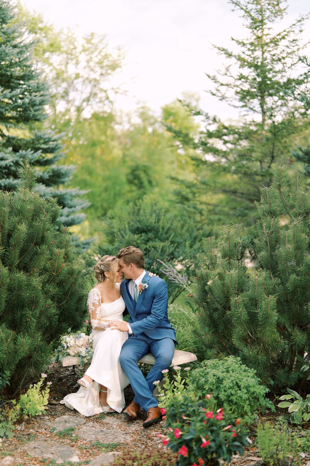 Classic and film-inspired wedding photography in Madison, Wisconsin. Bride and Groom intimate portrait sitting on a bench with trees.
