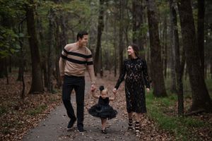 Family enjoying a playful moment together while walking on a forest trail.