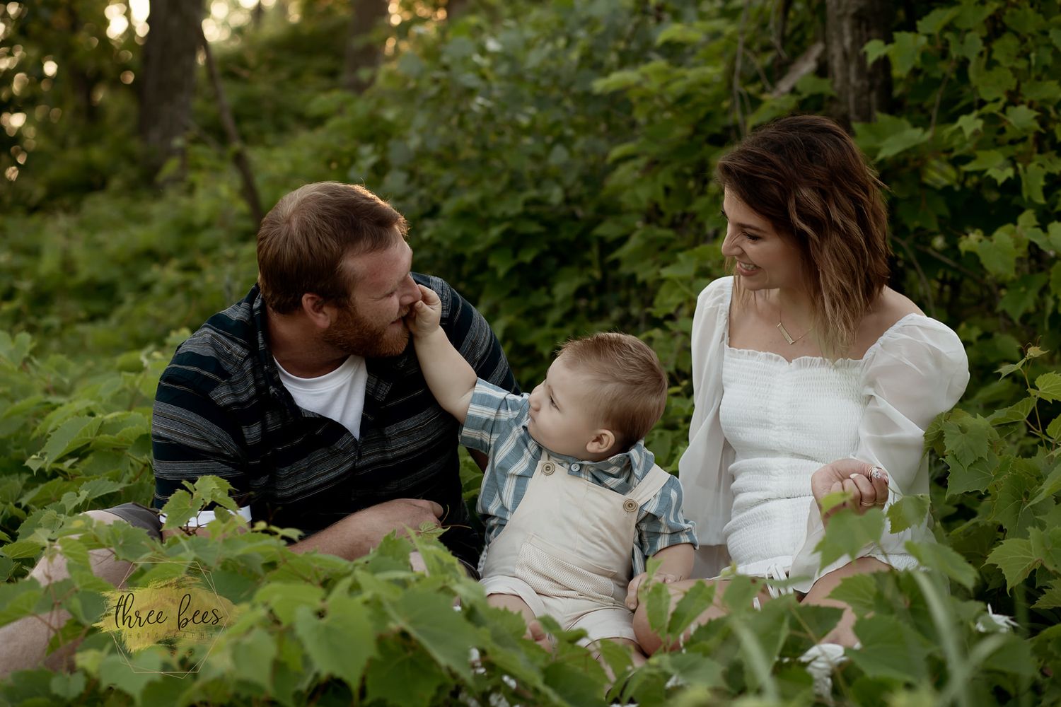 A family moment captured in a lush green garden setting.