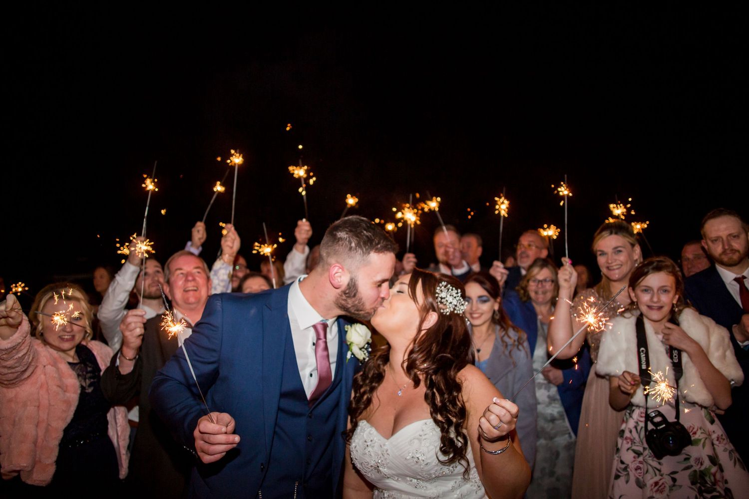 Wedding celebration at night with sparklers creating a magical atmosphere.