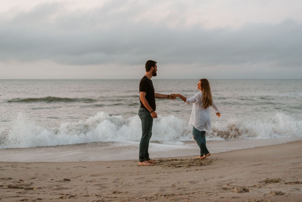 couple on the beach looking at each other hugging