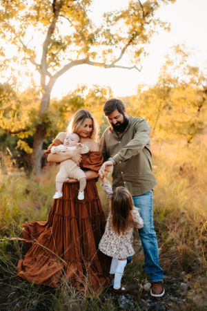 Family sharing intimate moment together in golden autumn setting.