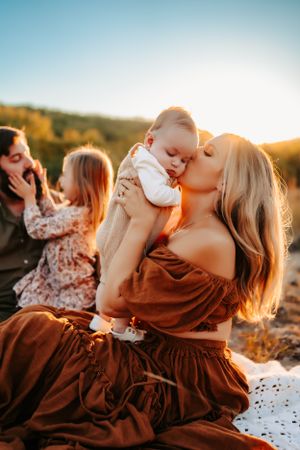 Tender family moments captured during golden hour in a rustic outdoor setting.