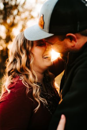 A romantic sunset portrait shows a tender moment between a couple with golden light streaming between them.