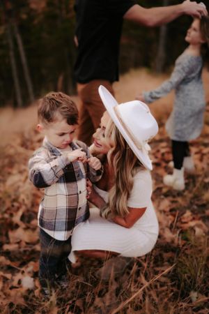 Sweet interaction captured during autumn family photoshoot in fallen leaves.