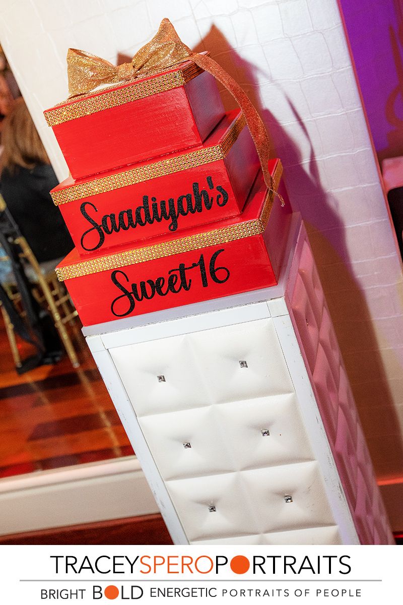 Red decorative Sweet 16 party boxes stacked with gold trim and custom text.