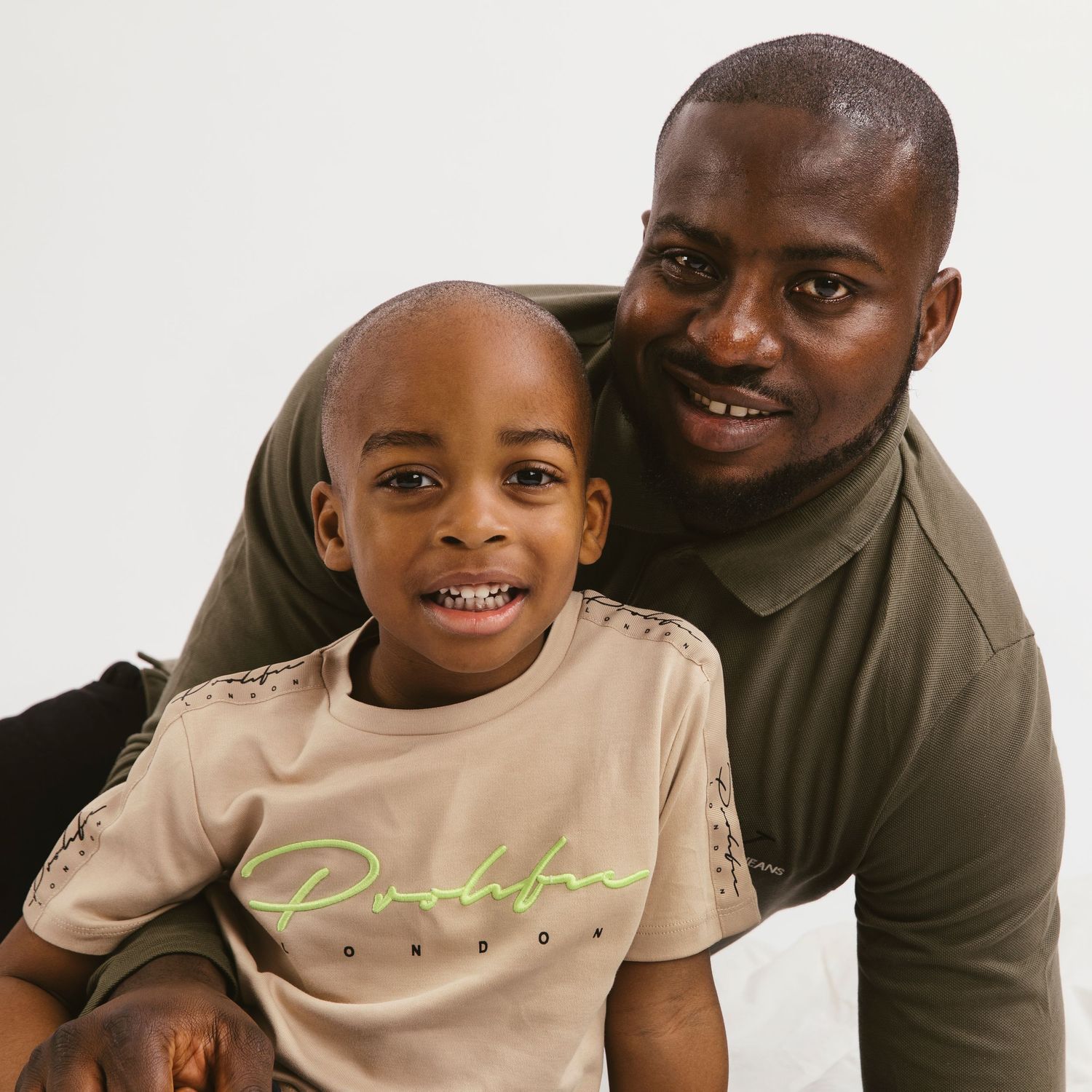 A heartwarming portrait of a parent and child smiling together against a white background.