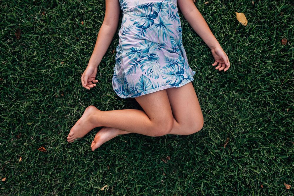 girl laying in the grass in backyard in chesapeake, virginia