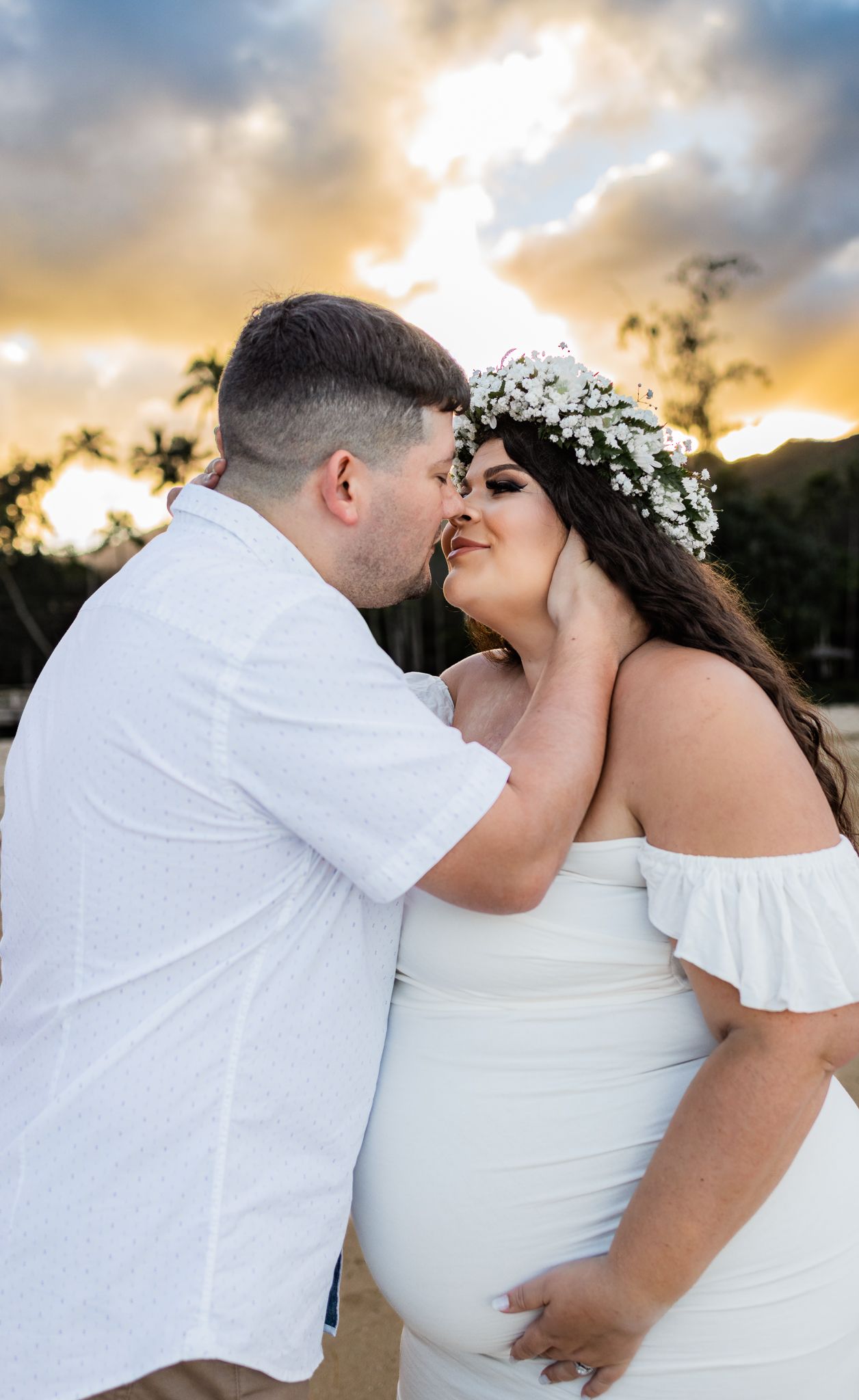 Romantic sunset beach wedding moment with couple in white attire.
