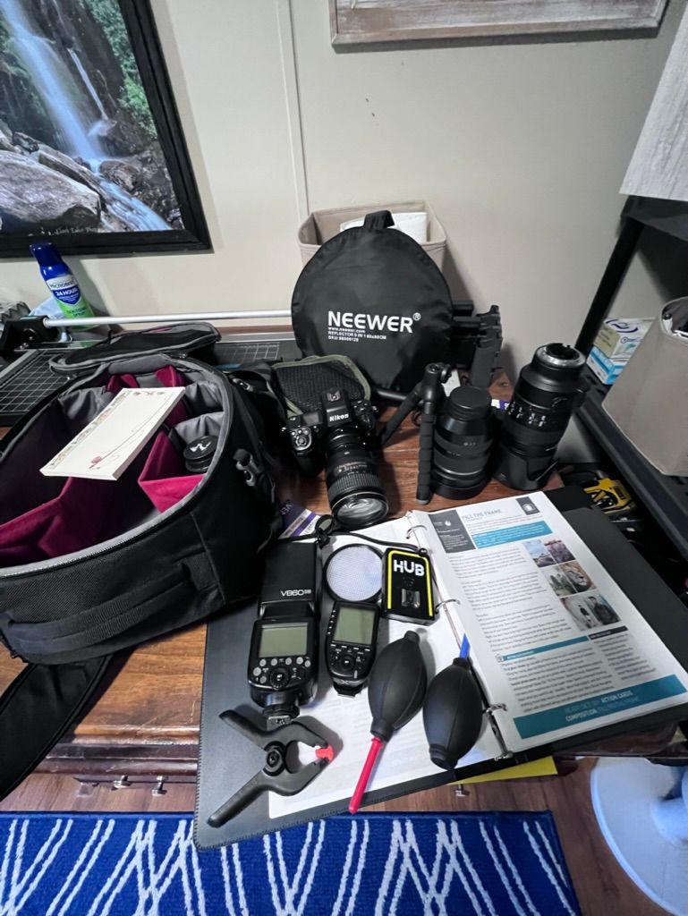 Collection of professional camera gear and accessories laid out on a blue rug.