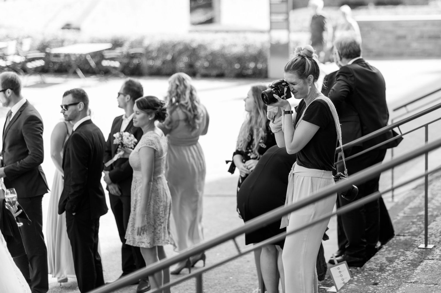 Wedding party lined up on outdoor steps in black and white photography.