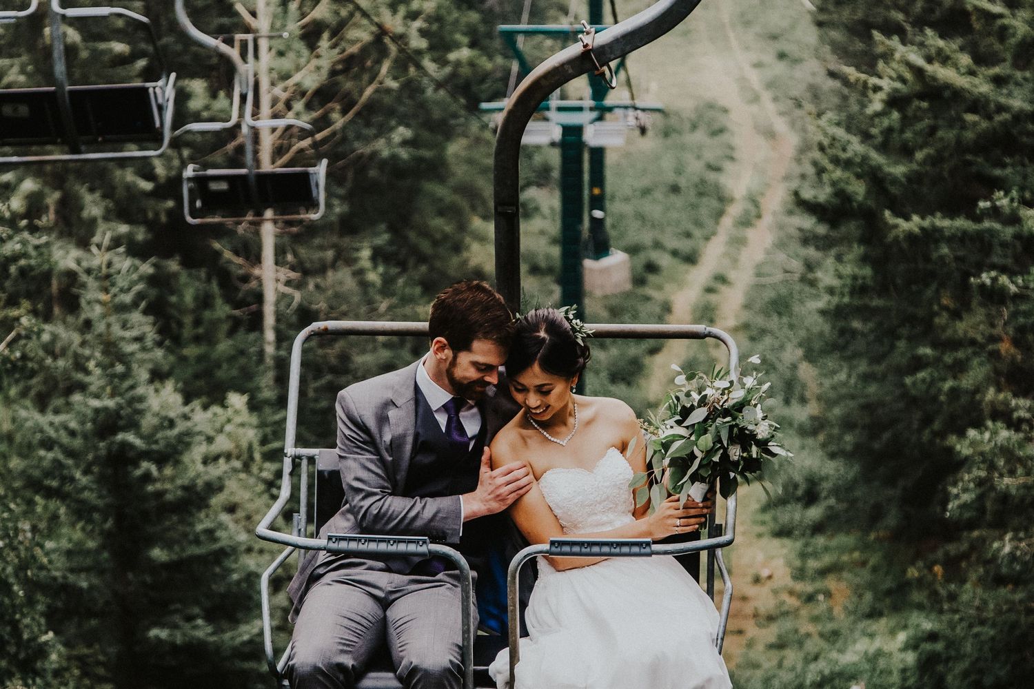 Bride and groom cuddle in Mount Norquay chairlift