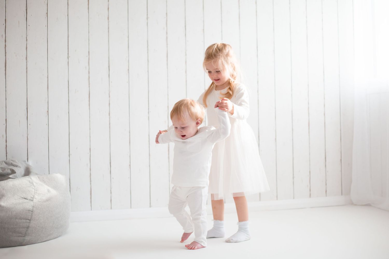 sister and younger brother walking in the photo studio