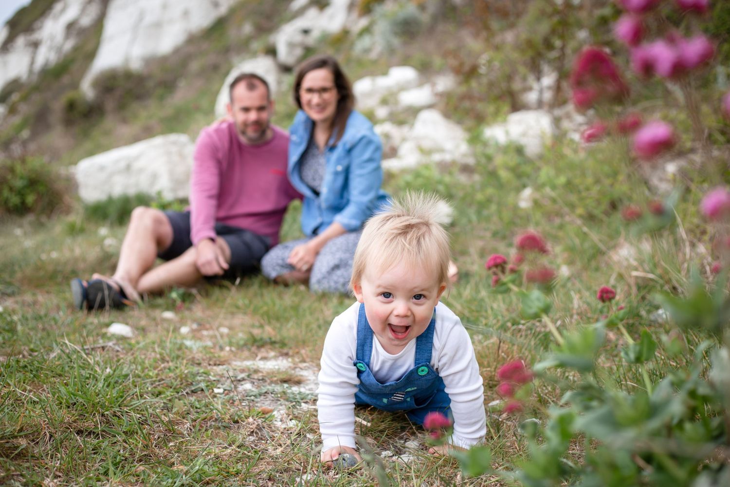 family of three playing near the cliffs in eastbourne