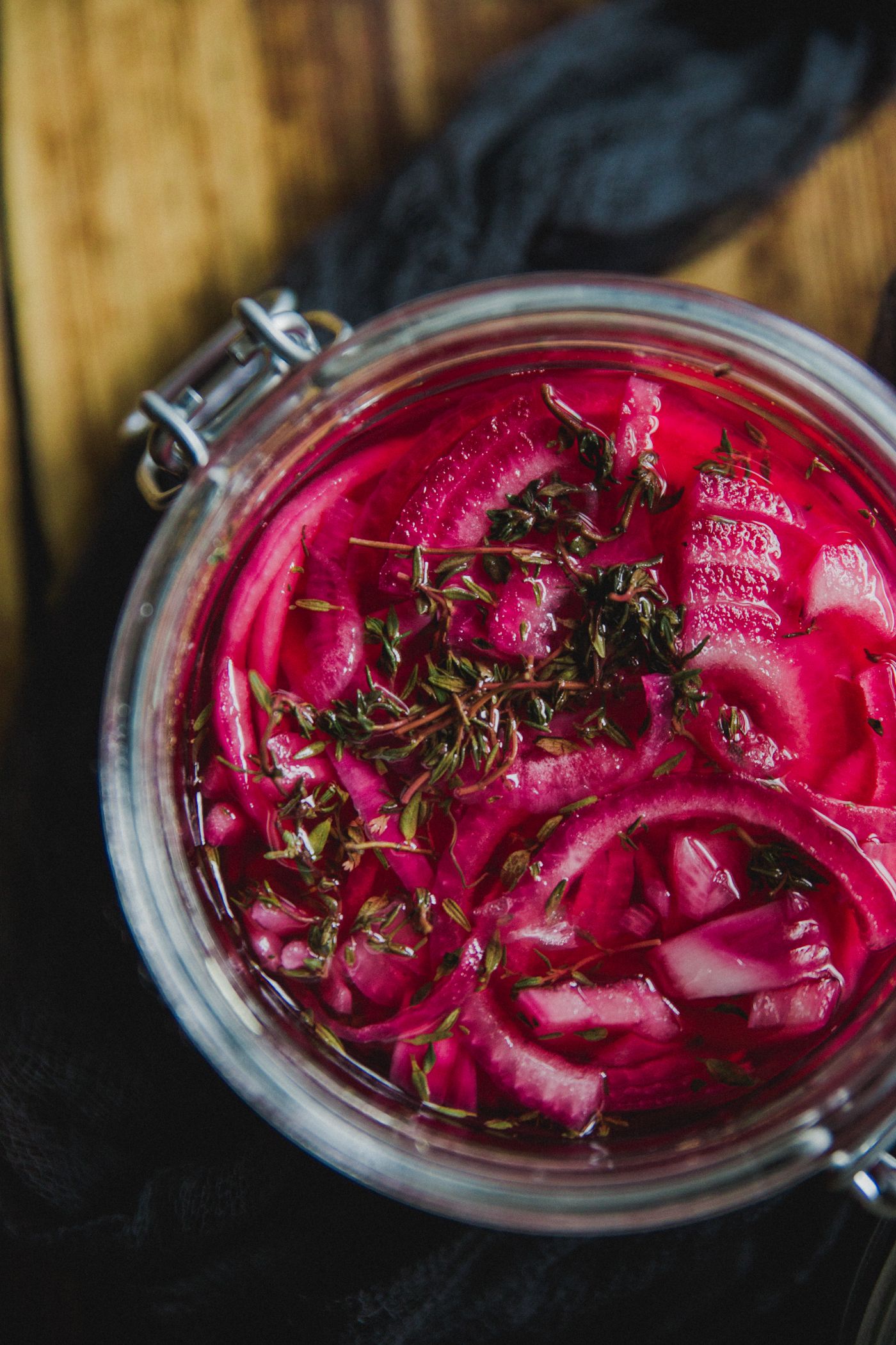 Pickled red cabbage with herbs in glass jar photographed from above.