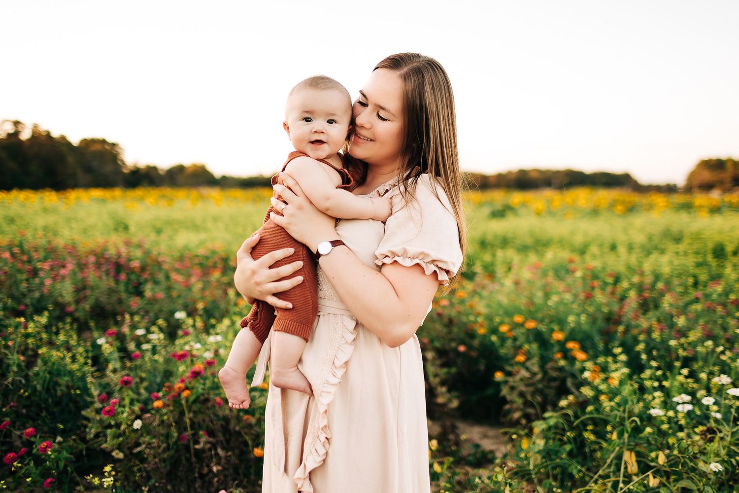 Mother and baby share tender moments in a vibrant wildflower meadow during golden hour in Milton FL
