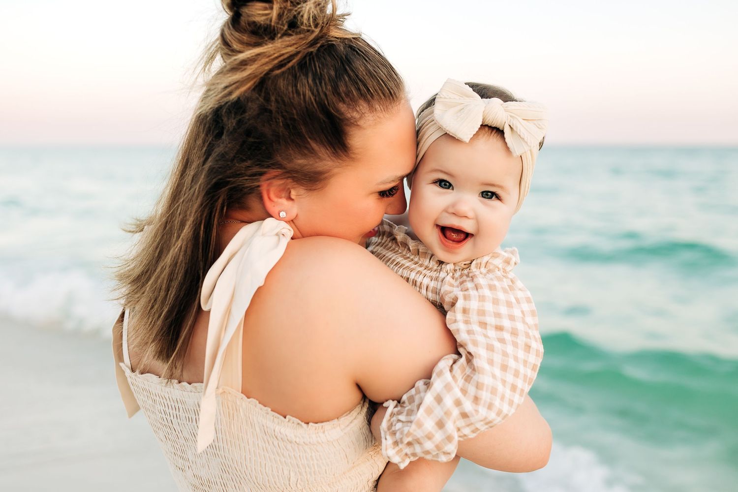 Happy parent and baby share tender moments of laughter and joy along a serene turquoise beach destin Florida
