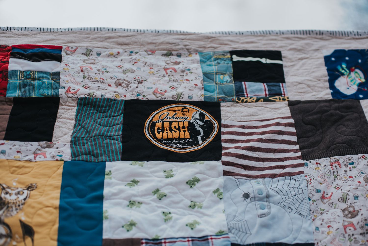 Johnny Cash onesie is a patch on a memory quilt made from baby clothes.