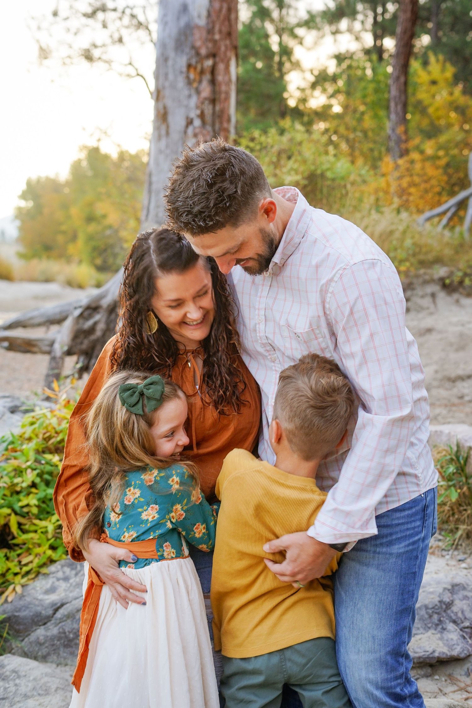 Family shares intimate moment together outdoors during fall photoshoot.