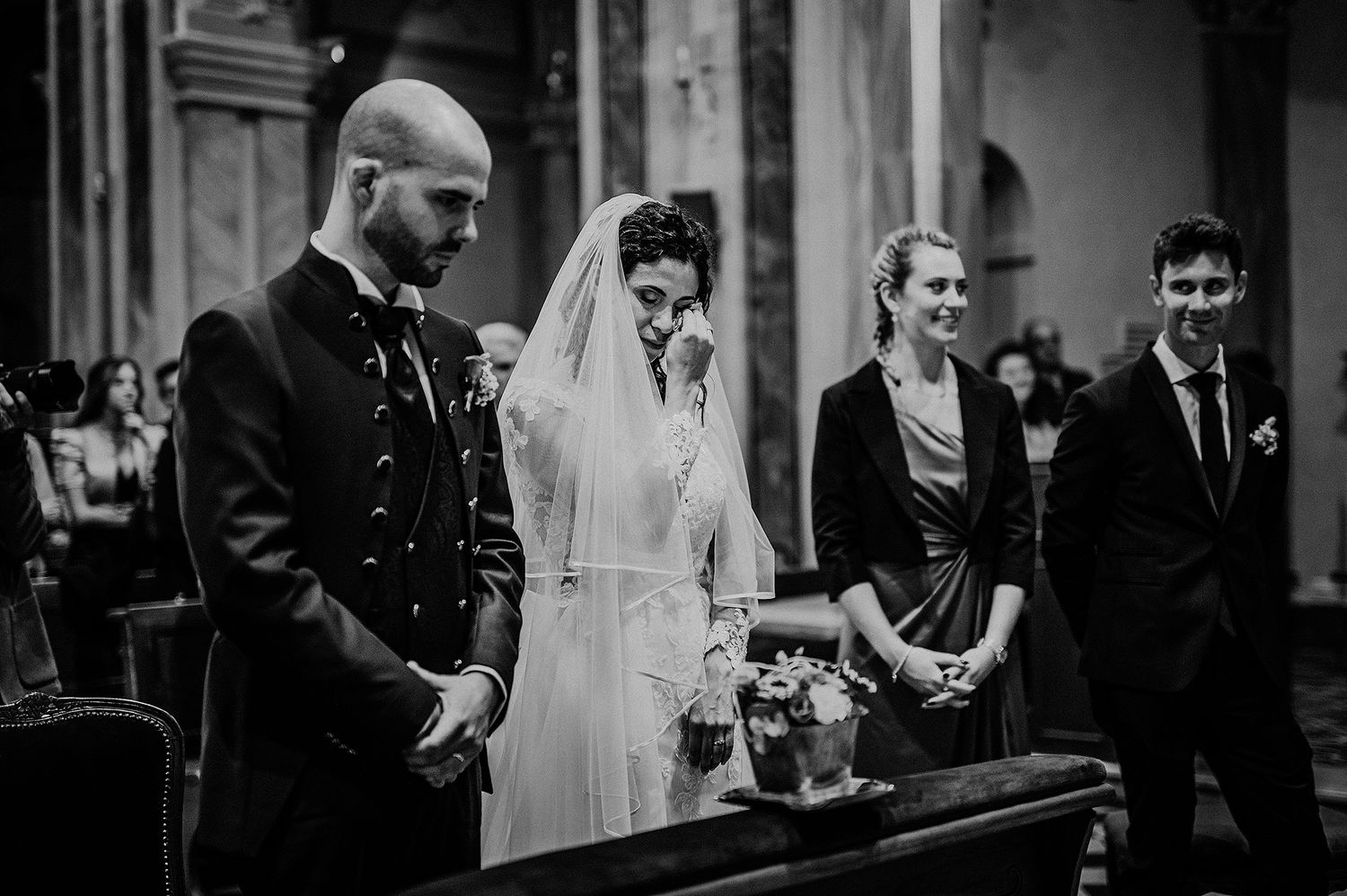 Bride and groom share an emotional moment with witnesses during a church wedding ceremony.