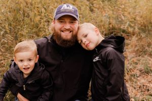 Father and son bonding moment in casual black outfits during fall photo session.