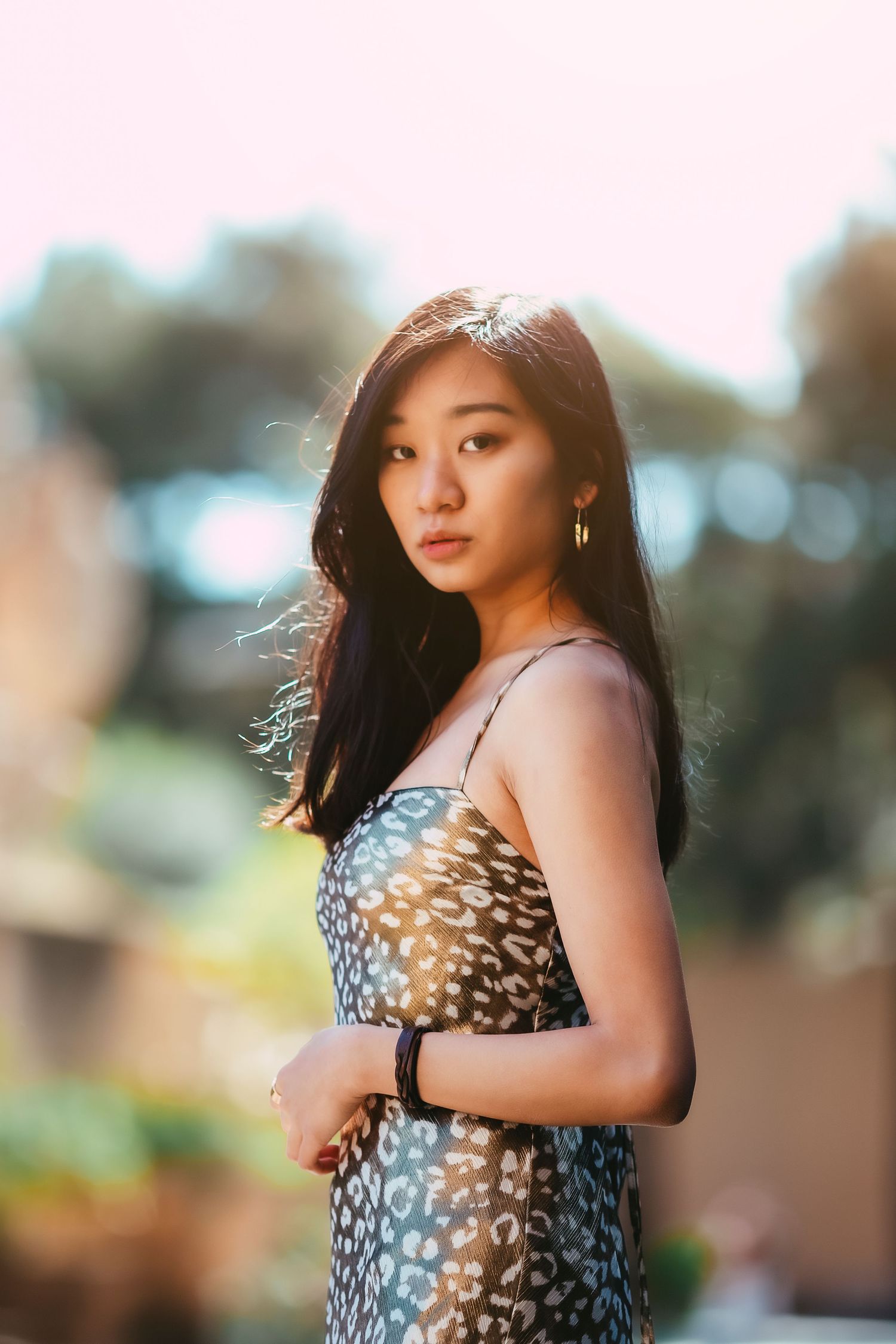 Elegant portrait of a woman in an animal print dress with soft focus background.