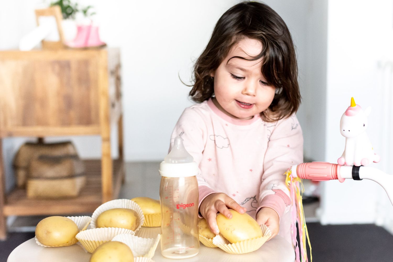 Toddler Isla having a tea party using potatoes as cupcakes
