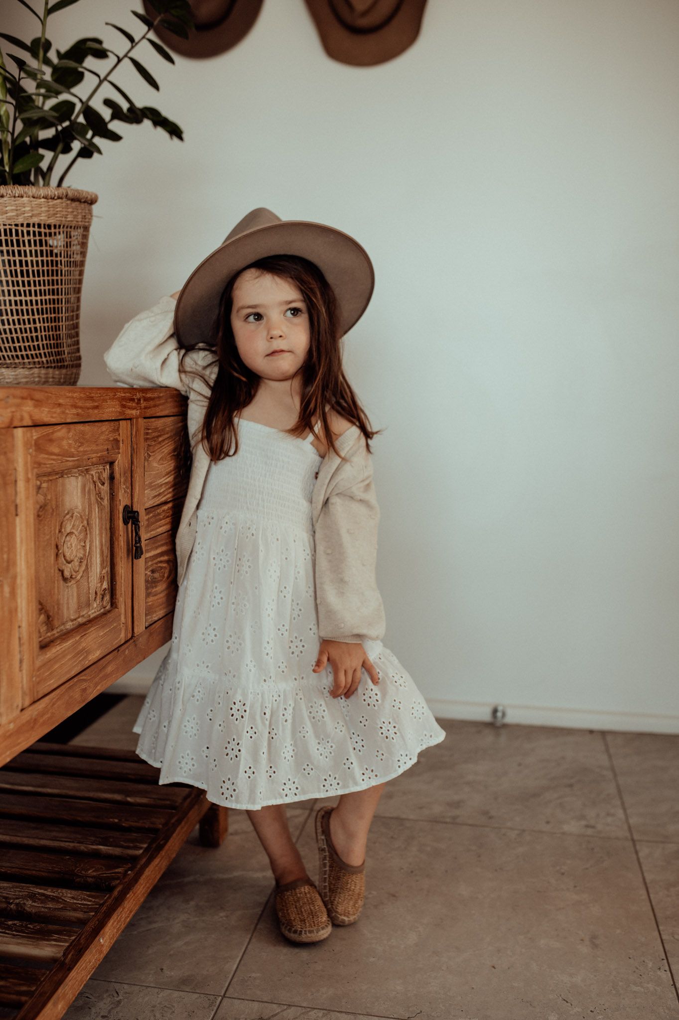 Cute image of photographers daughter in a cowboy hat and white dress