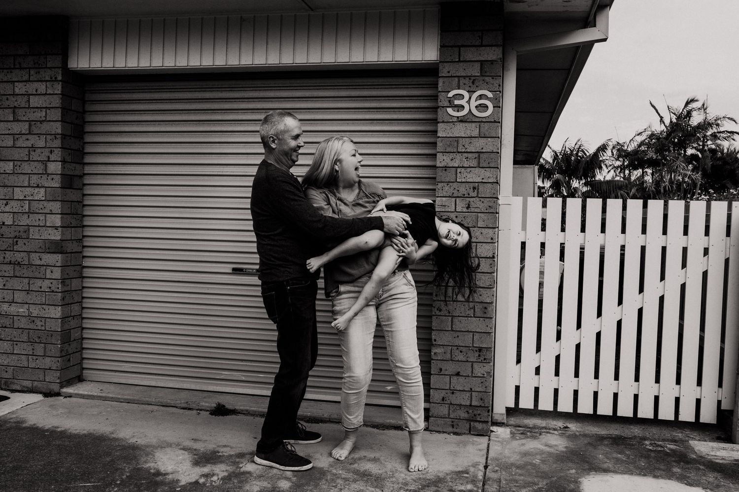 Black and white fun family candid photo outside our house in Port Macquarie