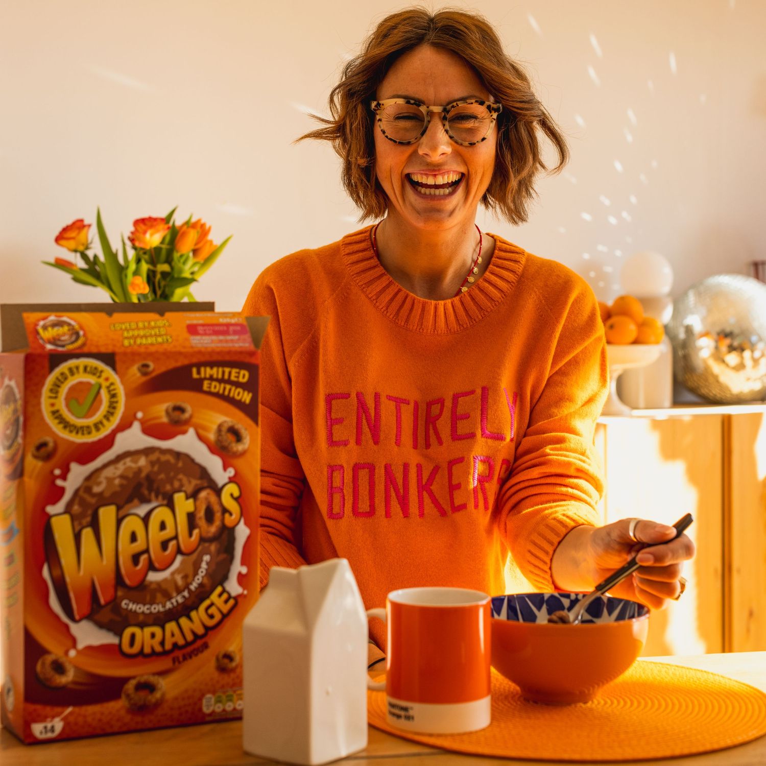 Sussex influencer model laughing over a bowl of Weetos for Instagram content, warm toned to match the product placement.