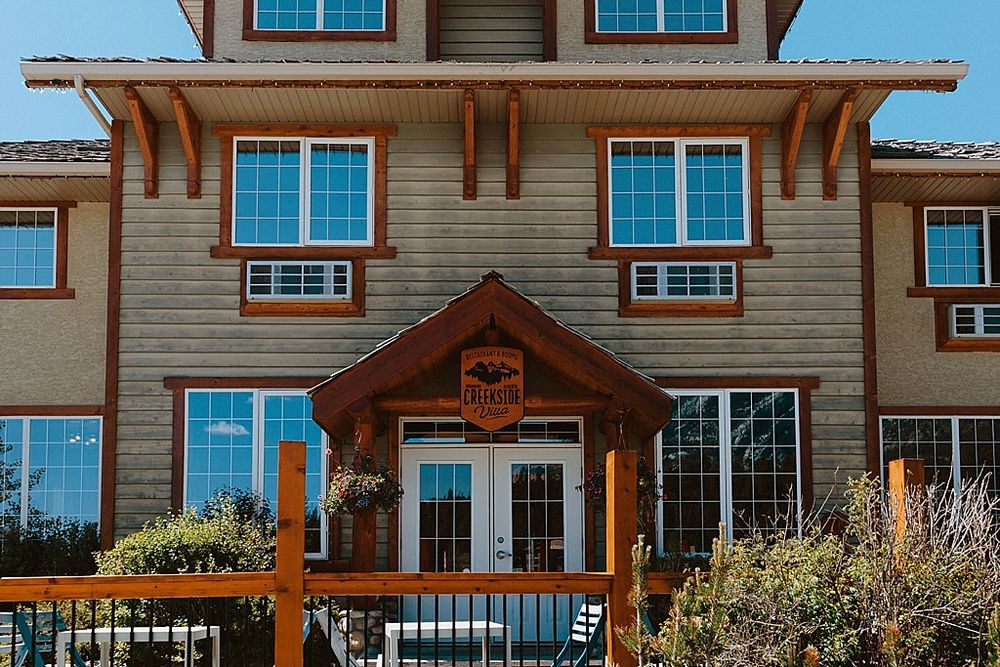 Rustic wooden lodge building with multiple windows and mountain scenery.