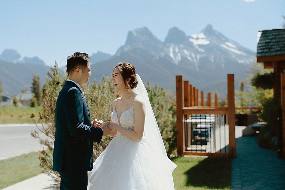 A wedding ceremony takes place against majestic mountain peaks on a bright sunny day.