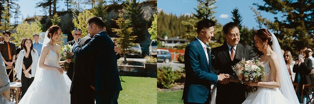 Wedding ceremony taking place on sunny day with mountain landscape in background.