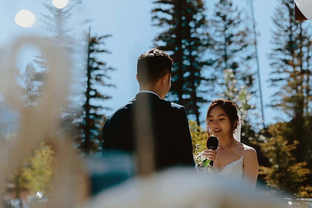 Intimate wedding ceremony exchange under bright blue mountain skies.