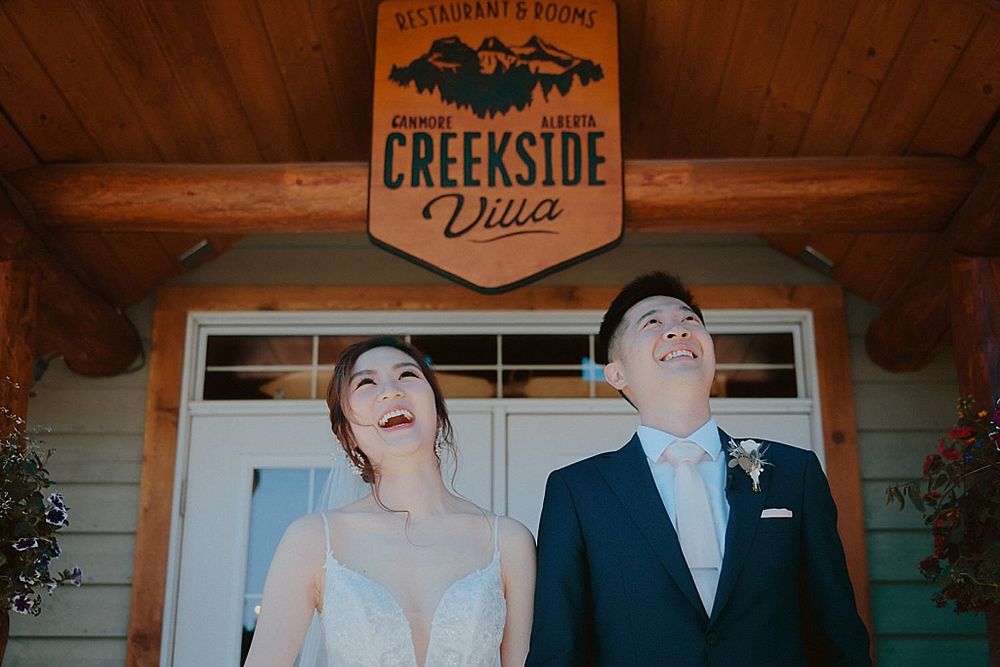 Joyful couple laughing outside Creekside Drive venue.