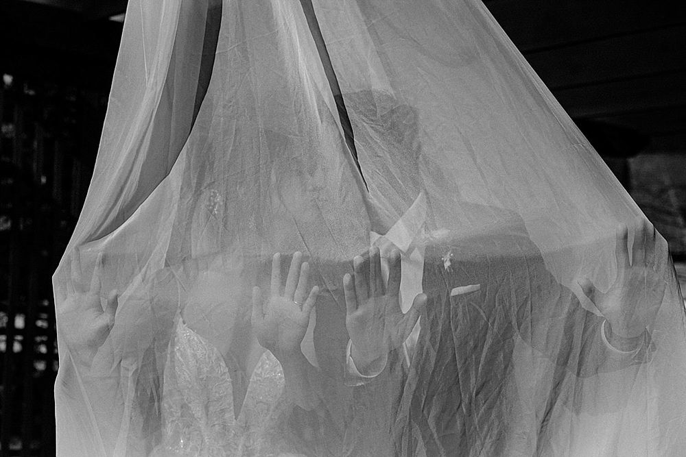 Close-up details of a flowing white wedding dress train with delicate lace patterns.