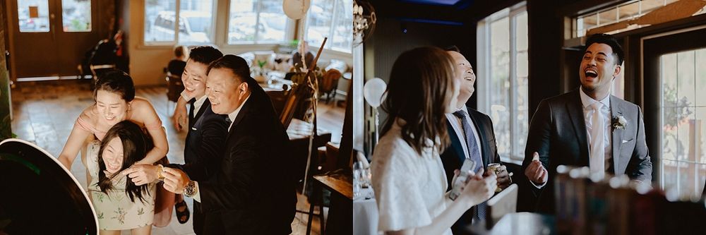 Wedding guests mingling and celebrating in an intimate indoor venue with chandeliers.