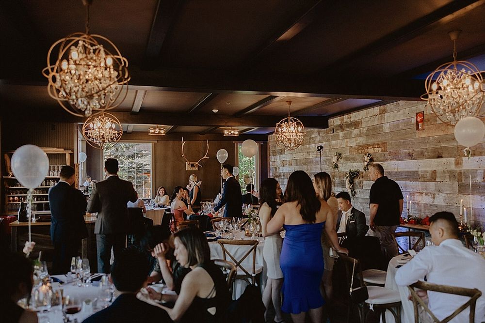 Wedding celebration in a rustic-modern venue with exposed brick walls and hanging crystal lights.