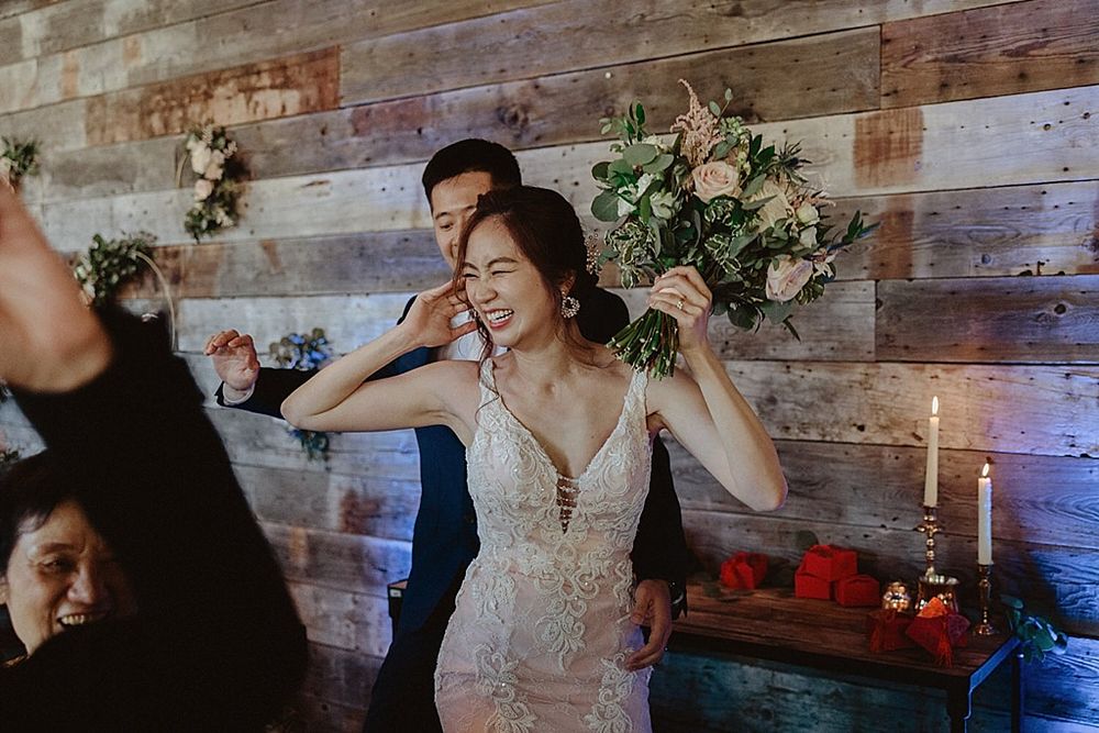 Wedding reception space featuring rustic wood walls and romantic floral arrangements.