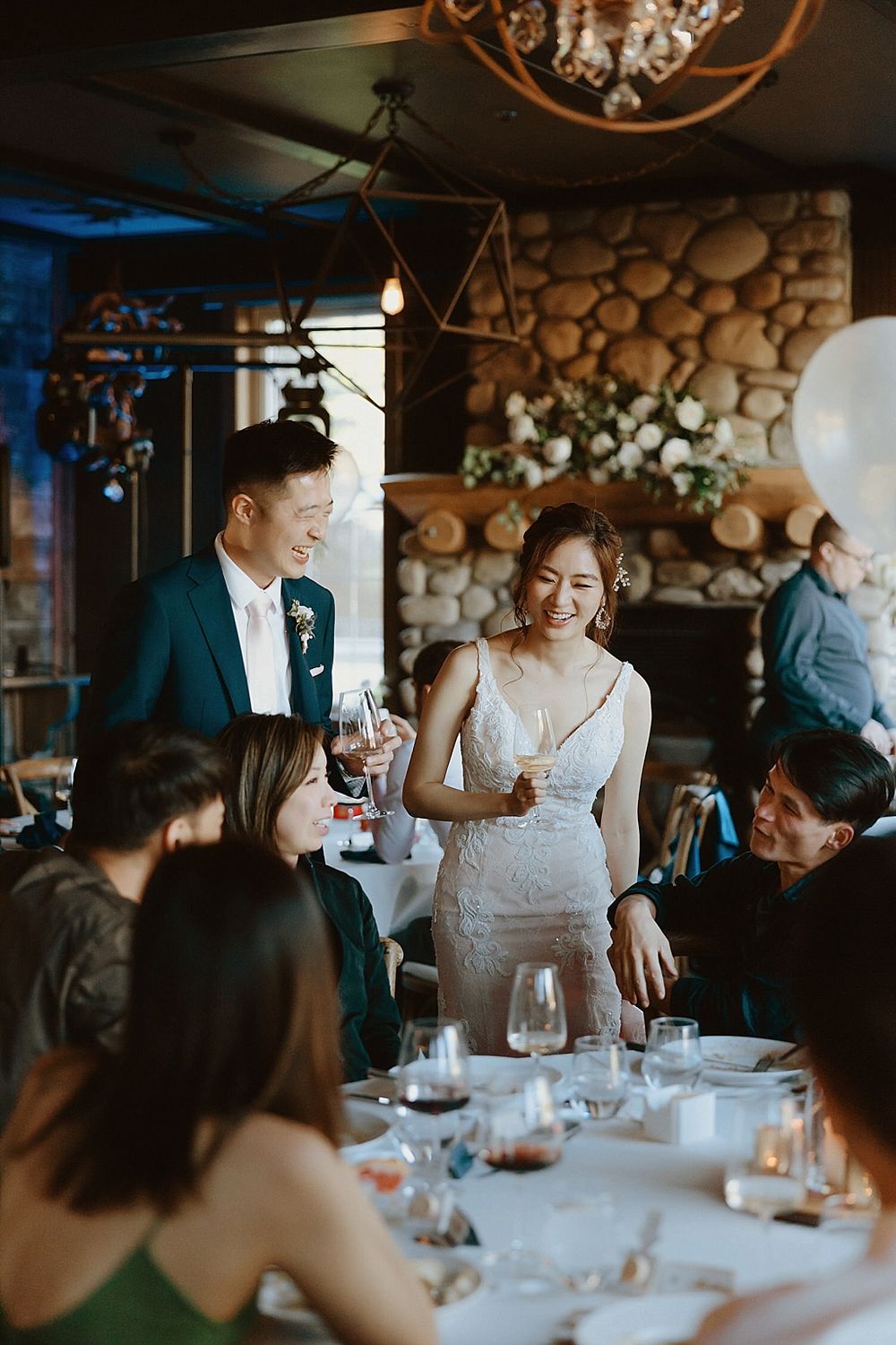 Wedding celebration in a rustic venue with wooden wall accents and elegant lighting fixtures.